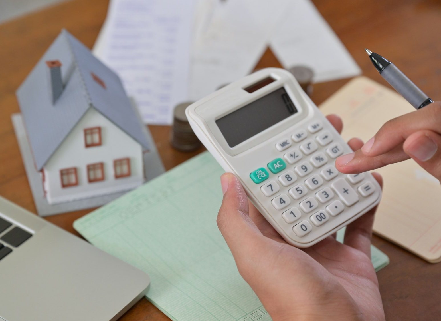 Hand is using calculator to calculate the home expenses.